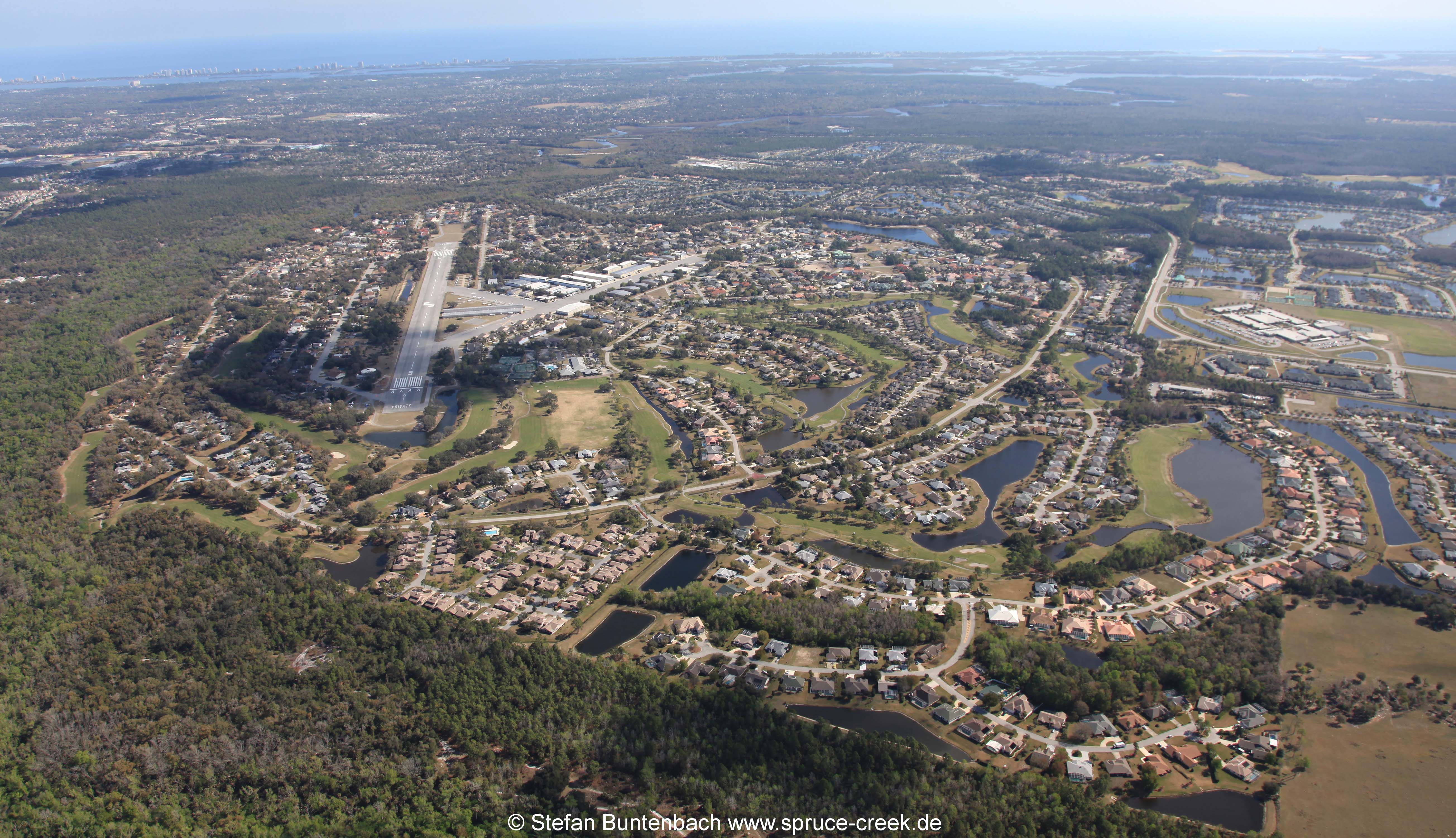Luftaufnahme des Spruce Creek Airpark in Florida. Airportcode 7FL6. Im Hintergrund der Atlantik.
